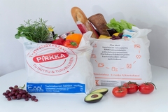 Image grocery shopping bags filled with fresh bread, vegetables, herbs, grapes, tomatoes and avocado on white background